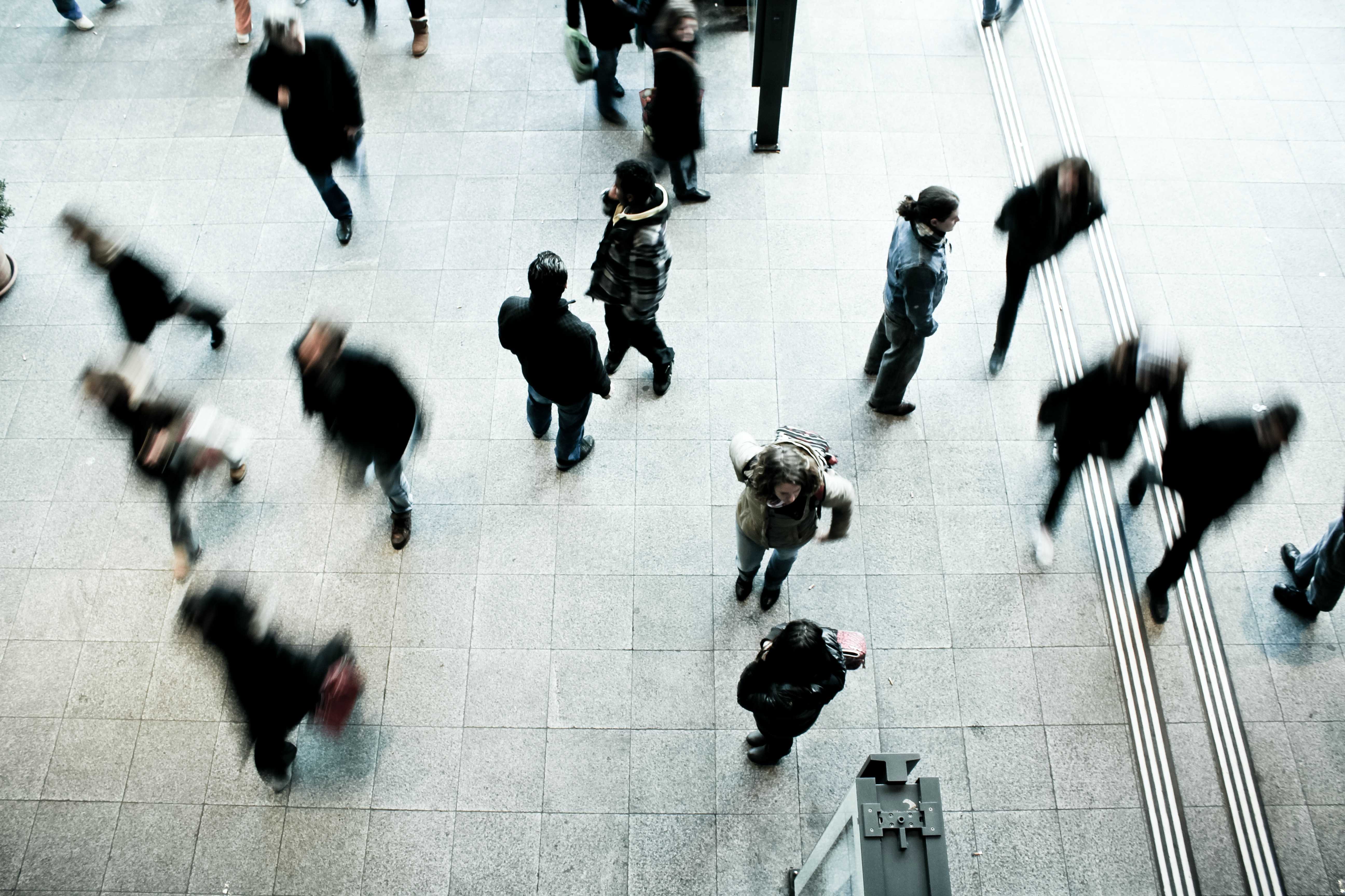 Lots of people walking at a station